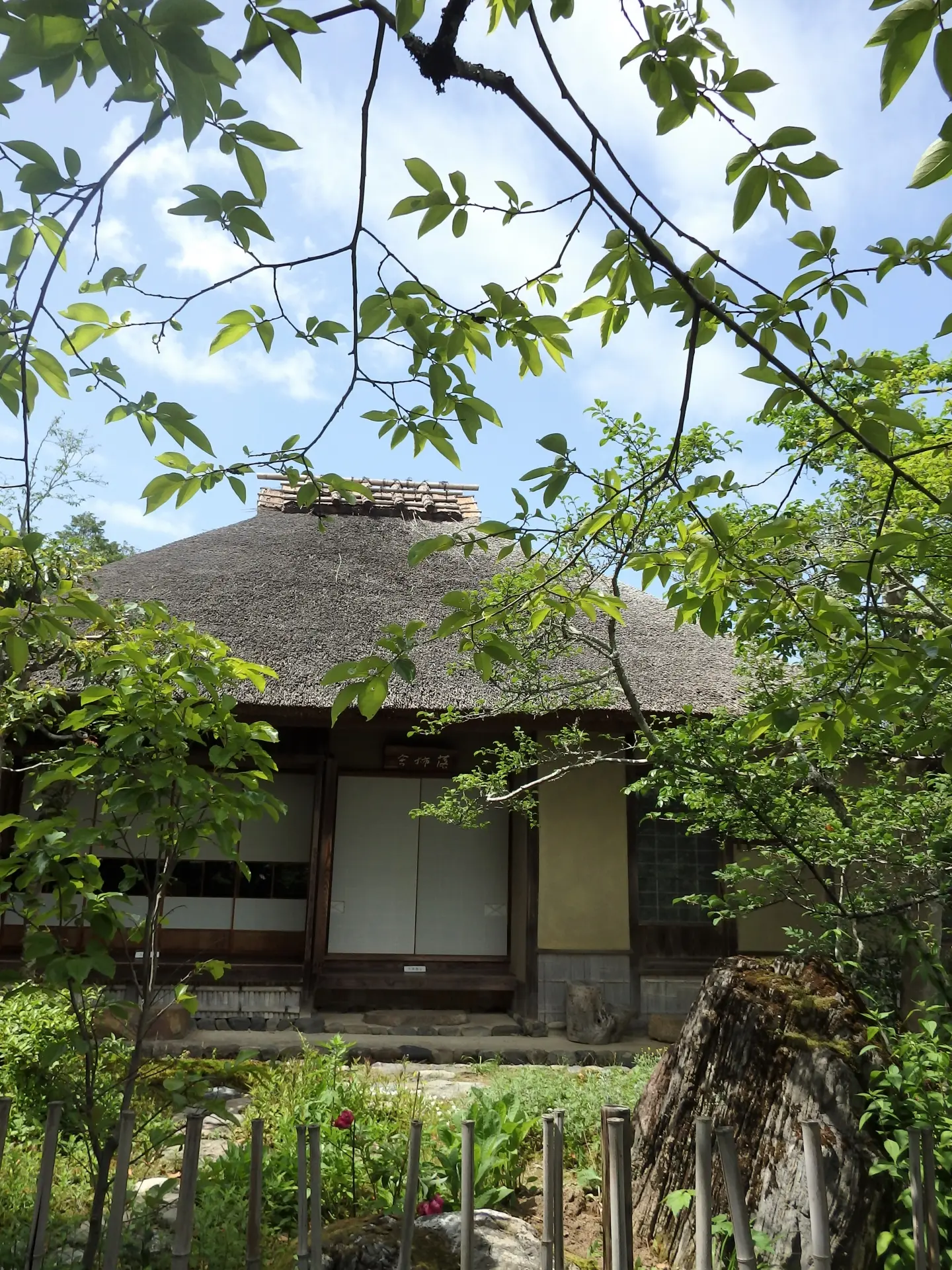 京都・嵯峨野の落柿舎にある茅葺きの庵と庭